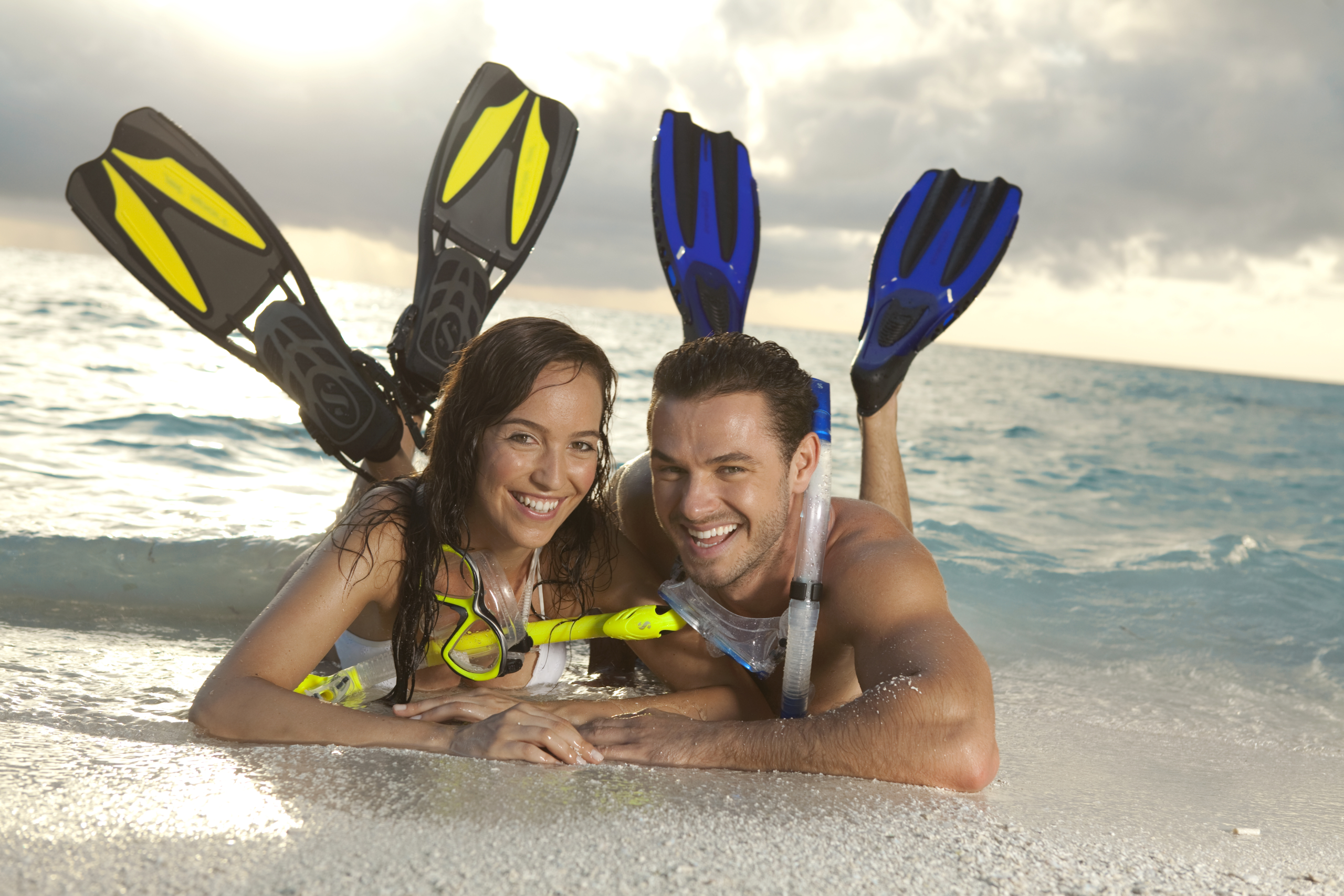 Happy couple on the beach with snorkel equipment